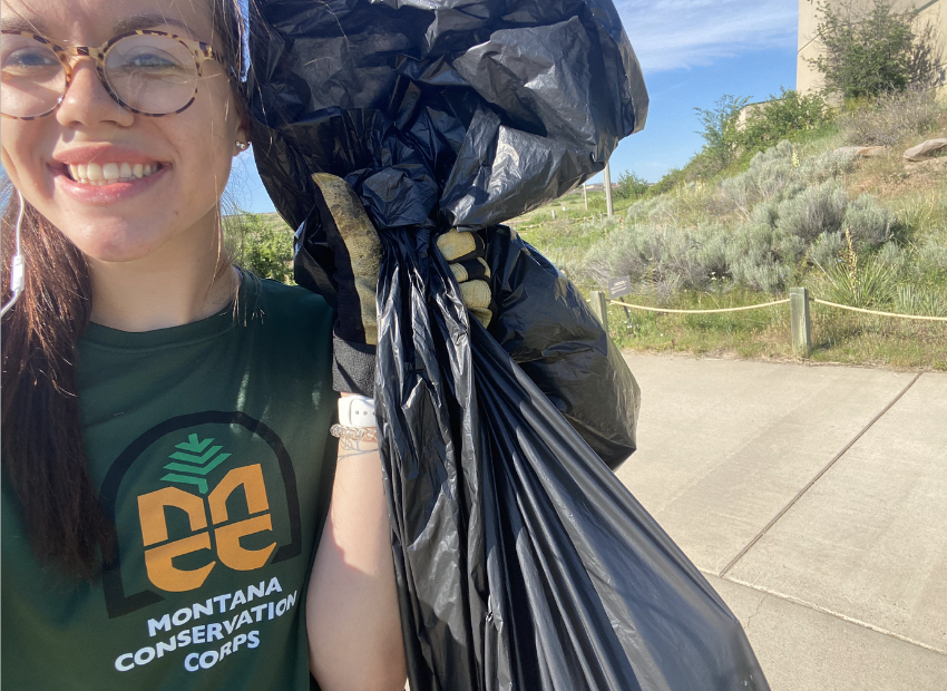 Montana Conservation Corps worker with a trash bag.