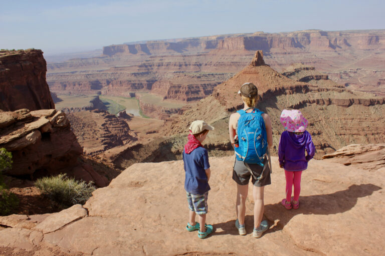 A woman and two children look out at a Grand Canyon vista