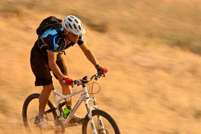 A cyclist concentrates while riding through bumpy terrain