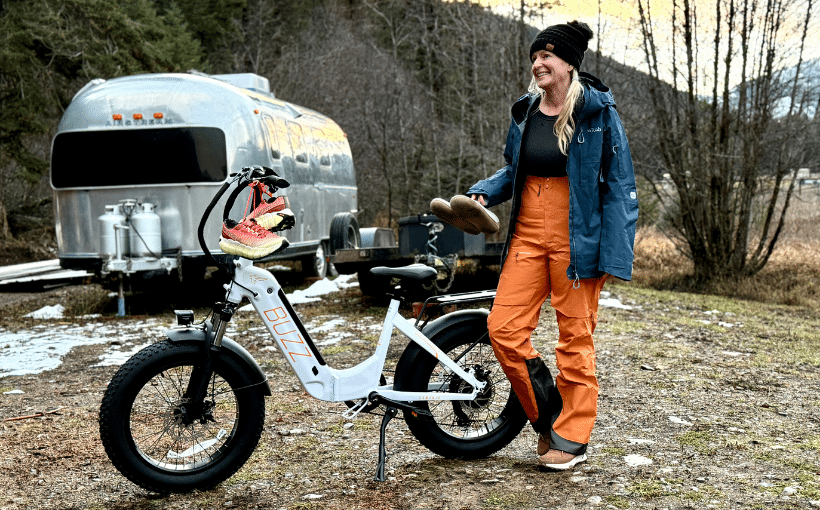 Woman with Buzz electric bike wearing a Rab pro ski outfit with bibs and a coat.