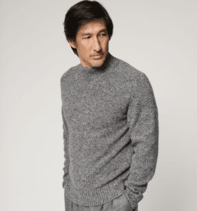 Man looking to the side wearing a gray Woodlan Mitchell Alpaca Wool Sweater