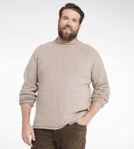 Man with a beard smiling wearing a Men's Bean's Classic Ragg Wool Sweater, Rollneck with his hand in his pocket. 